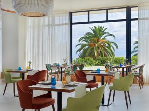 a restaurant with tables and chairs and a large window at H10 Imperial Tarraco 4 Sup in Tarragona