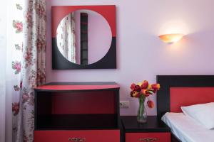 - une chambre dotée d'un mobilier rouge et noir et d'un miroir dans l'établissement 1-st Line Izvora Sea View Apartments on Golden Sands, aux Sables d'or