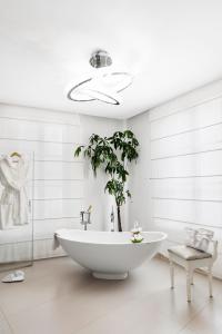 baño con bañera blanca y planta en Residenza d'Epoca Palazzo Borghesi, en Siena