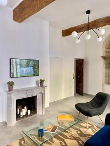 ein Wohnzimmer mit einem Kamin und einem Stuhl in der Unterkunft Grand confort au cœur de Nîmes in Nîmes