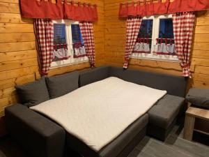 Bett in einem Zimmer mit 2 Fenstern in der Unterkunft Ferienhaus am Goldbach in Freiberg