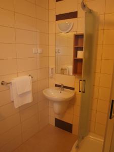 a bathroom with a sink and a toilet and a mirror at Hotel Olimpijski in Oświęcim