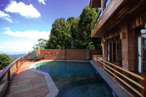 una piscina en una terraza junto a una casa en Bali Jegeg Munduk Hotel, Bar, and Restaurant, en Munduk