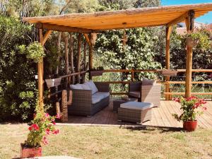 a wooden gazebo with a couch and chairs on a deck at maison en Camargue in Saintes-Maries-de-la-Mer