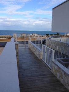 une promenade menant à un balcon donnant sur l'océan dans l'établissement Charlotte's House Locaz. Turistica, à Polignano a Mare