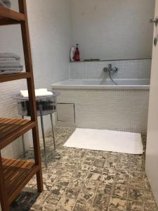ein Badezimmer mit einer Badewanne und einem Teppich in der Unterkunft Guesthouse Poppies in Ostende
