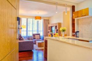 a kitchen and living room with a couch in a room at Reata Apartment Hotel in Nairobi
