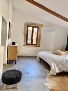 a bedroom with a bed and a table and a window at Grand confort au cœur de Nîmes in Nîmes