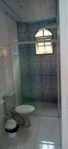 a bathroom with a toilet and a shower at Casa Bom Sossego in Boicucanga