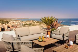a patio with a couch and chairs and a table at H10 Imperial Tarraco 4 Sup in Tarragona
