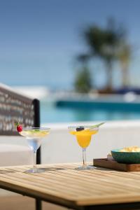 two cocktails sitting on top of a wooden table at H10 Imperial Tarraco 4 Sup in Tarragona