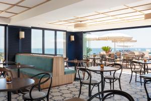 a restaurant with tables and chairs and windows at H10 Imperial Tarraco 4 Sup in Tarragona