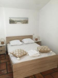 a bed with white sheets and pillows in a bedroom at maison en Camargue in Saintes-Maries-de-la-Mer