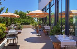 a patio with tables and chairs with umbrellas at H10 Imperial Tarraco 4 Sup in Tarragona
