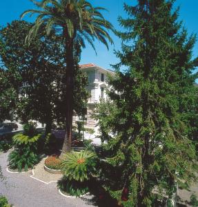 una casa con dos palmeras en un patio en Genovese Villa Elena Residence, en Varazze