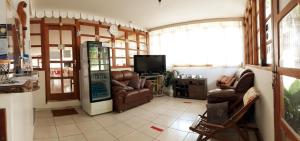 a living room with leather chairs and a television at Pousada Jubaia in Bonito