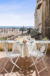 a table with plates of food on a balcony at Residenza d'Epoca Palazzo Borghesi in Siena