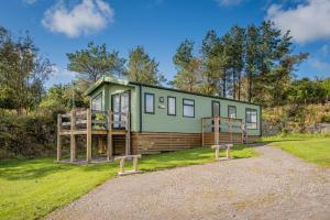 ein kleines grünes Haus auf einem Grasfeld in der Unterkunft Platinum Holiday Caravan in Bothel