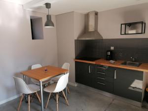 a kitchen with a wooden table and white chairs at Green Villas Douro in Gondomar