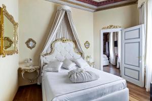 a bedroom with a white bed with a canopy at Residenza d'Epoca Palazzo Borghesi in Siena