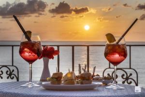 カーポ・ヴァチカーノにあるTonicello Hotel Resort & SPAのワイングラス2杯と食器一皿付きのテーブル