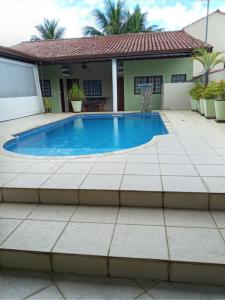 a swimming pool in front of a house at Casa Morada da Praia in Boracéia