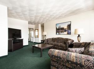 uma sala de estar com sofás e uma televisão de ecrã plano em The Business Inn em Ottawa