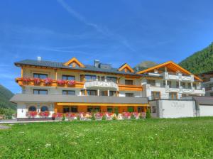 a large building with flowers in front of it at Hotel Verwall in Ischgl