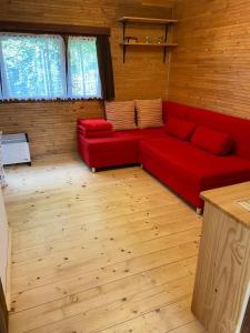 czerwoną kanapę w pokoju z drewnianą podłogą w obiekcie Chata Petrofka w mieście Zdislava