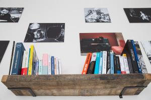 a wooden book shelf filled with books on a wall at Suites The Marcel in Sète