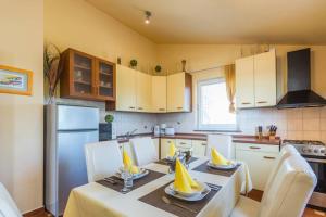 una cucina con tavolo e tovaglioli gialli di Apartman Stela a Poreč (Parenzo)