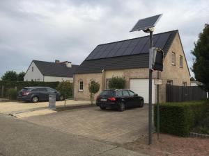 un sistema solare su una casa con due auto parcheggiate di Julie's Place a Westerlo