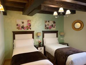 Cet hébergement comprend 2 lits dans une chambre dotée de murs verts et de plafonds en bois. dans l'établissement Villa Fontanas, à Hontanas
