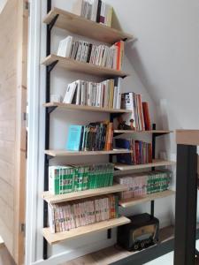 a book shelf filled with books in a room at La petite brise in Plouër-sur-Rance