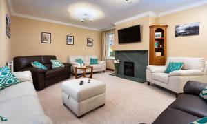 a living room with couches and a fire place at Briarwood House in Keswick