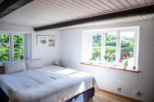 ein Schlafzimmer mit einem Bett und zwei Fenstern in der Unterkunft Ravlunda Byaväg 12 in Kivik