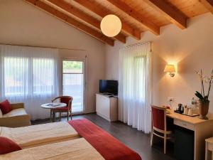 a bedroom with a bed and a desk and a television at Chalet-Gafri - BnB - Frühstückspension - Service fast wie im Hotel in Wilderswil