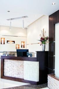 a lobby with a reception counter with flowers at Reata Apartment Hotel in Nairobi +84 photos