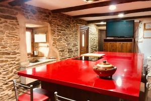 a red island in a kitchen with a red counter top at Casa rural entre Santiago Compostela y La Coruña in Ordes