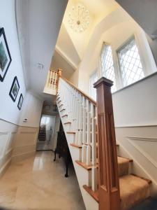 a staircase in a home with a vaulted ceiling at The Old Schoolhouse of Warren Lodge Boutique Cottages in Dromod