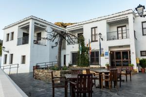 a patio with a table and chairs in front of a building at Villa Turistica de Bubion in Bubión