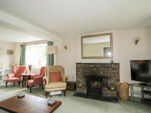 a living room with a fireplace and a mirror at Fell Foot in Holmrook