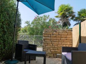 een patio met stoelen en een tafel met een parasol bij Studio avec terrasse et parking 200m plage et commerces in La Couarde-sur-Mer