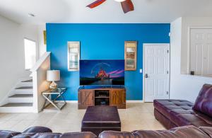sala de estar con sofá y pared azul en Fantastic Lakeview Townhome near Disney en Kissimmee