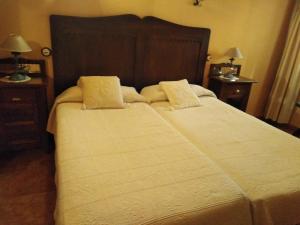 a bedroom with a large bed with two nightstands and two lamps at CASONA de los Peregrinos I in Cepeda