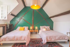 Duas camas num quarto com uma parede verde em Kasa Des Bois em Saint-Arnoult-des-Bois