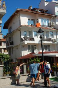 um grupo de pessoas em pé em frente a um edifício em The House Next to the Beach em Sozopol