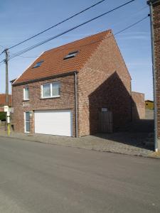 ein Backsteinhaus mit einer großen weißen Garage in der Unterkunft De Jölenberg in Heers