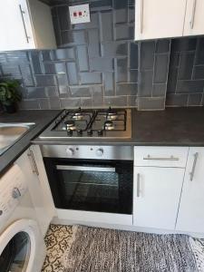 a kitchen with a stove top oven in a kitchen at Next to Aintree Golf Course in Aintree