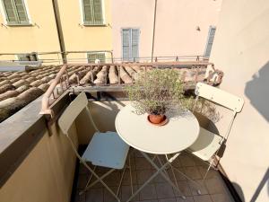 a table and two chairs and a plant on a balcony at Niki O. Apartments in Parma